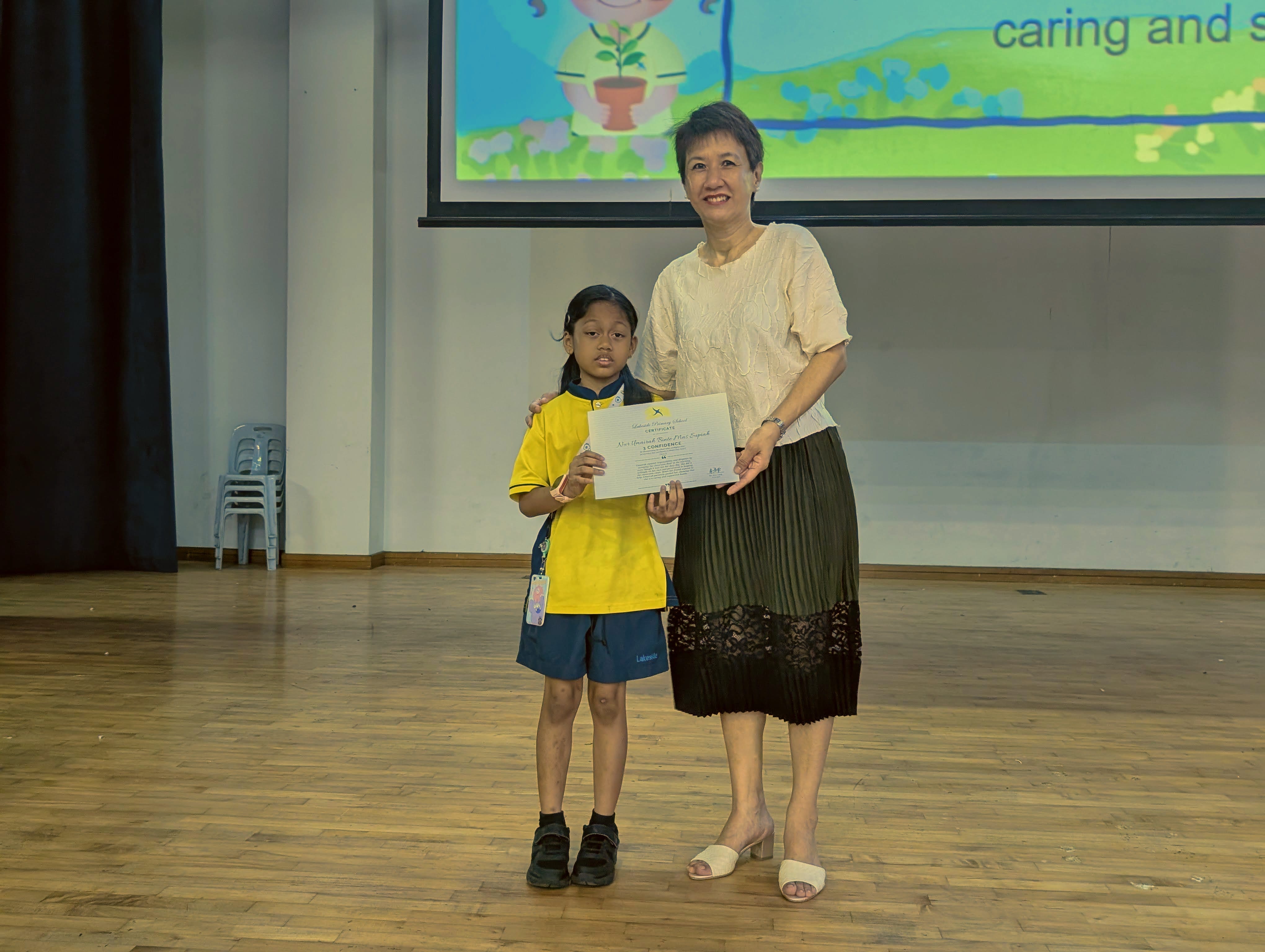 Umairah receiving her certificate from Mrs Liang